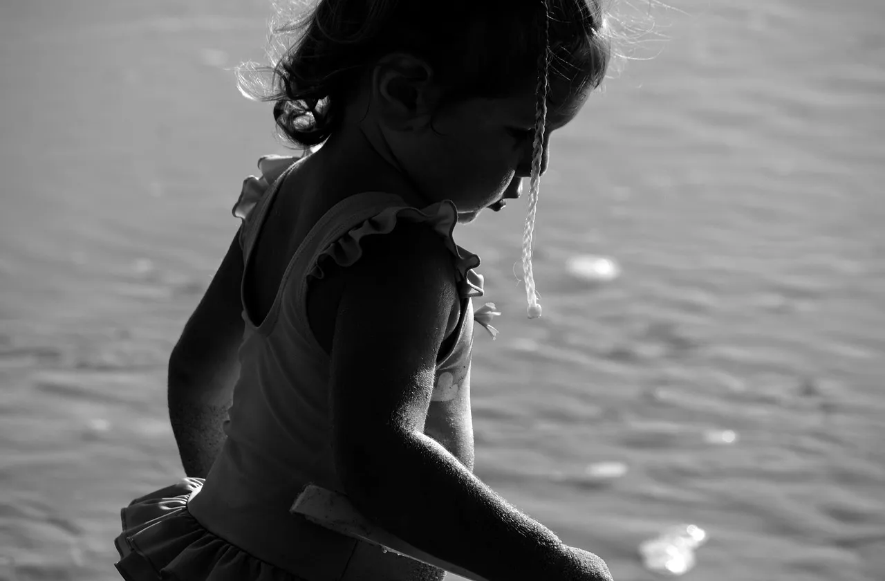 A young child looking down in sadness — the effects of spiritual abuse on children