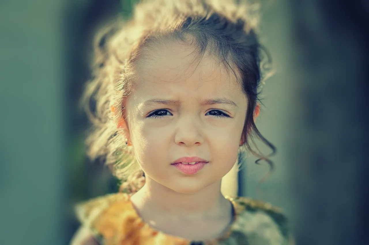 A young child with a worried, anxious expression — the effects of religious indoctrination on children
